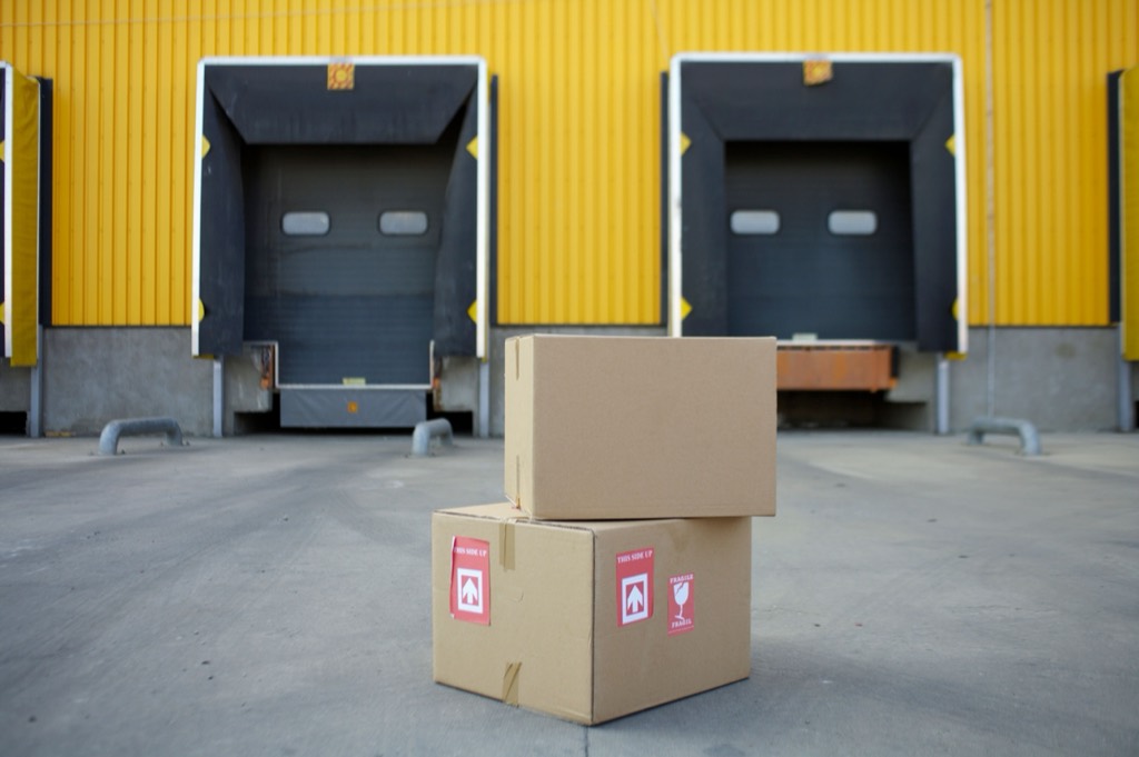 Weg einer Sendung vom Absender zum Empfänger Tore eines Logistik-Warenhauses mit gelber Wand als Umschlagplatz auf dem Weg einer Sendung vom Absender zum Empfänger